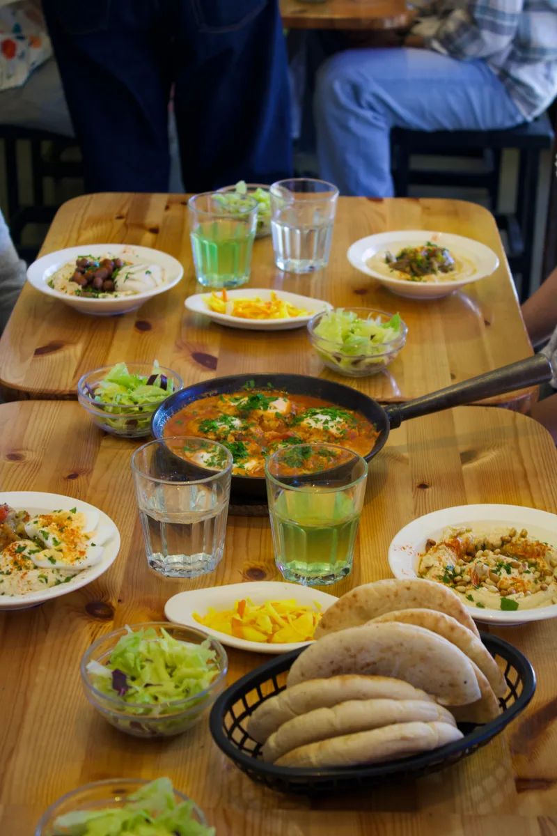 Table set with hummus, shakshuka, and sides